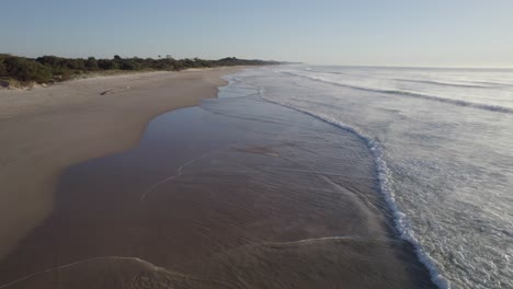 Surfista-Con-Tabla-De-Surf-Caminando-En-La-Playa-Coolum-Para-Surfear-Temprano-En-La-Mañana-En-La-Costa-Del-Sol,-Qld,-Australia