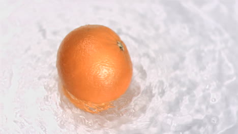 orange turning in water in super slow motion