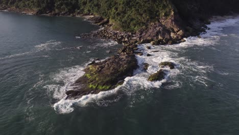 Drone-comes-close-to-a-rock-in-the-beach-in-a-beatifull-sunny-day