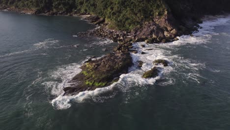 drone se acerca a una roca en la playa en un hermoso día soleado