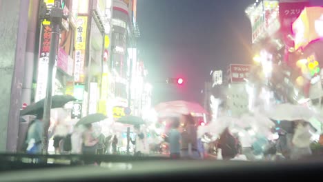 people who cross the crossing in tokyo shinjuku in the rain