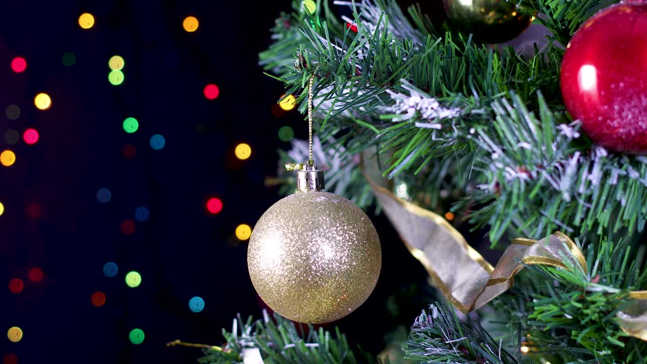 enfocando el árbol de navidad con adornos de brillo dorado y luces parpadeantes