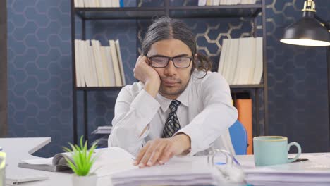 lazy office worker sitting at desk instead of working is distracted and pensive.