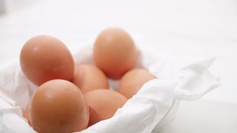 Close-up-male-hand-taking-brown-eggs-out-of-the-carton