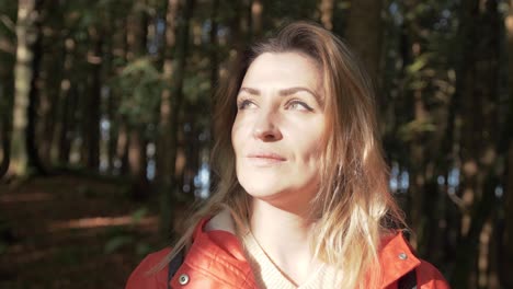 An-attractive-woman-walks-through-a-sunlit-forest