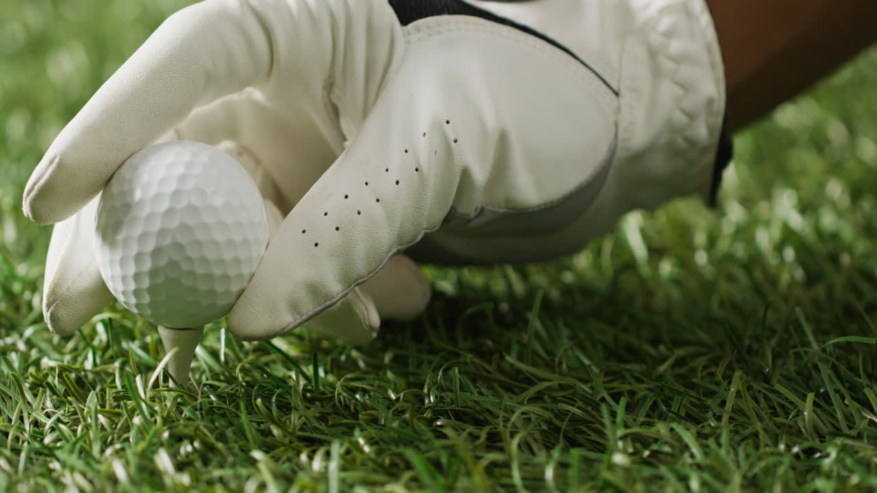잔디 위에 골프 공을 들고 있는 장갑으로 손을 고, 공간을 복사하고, 느린 동작