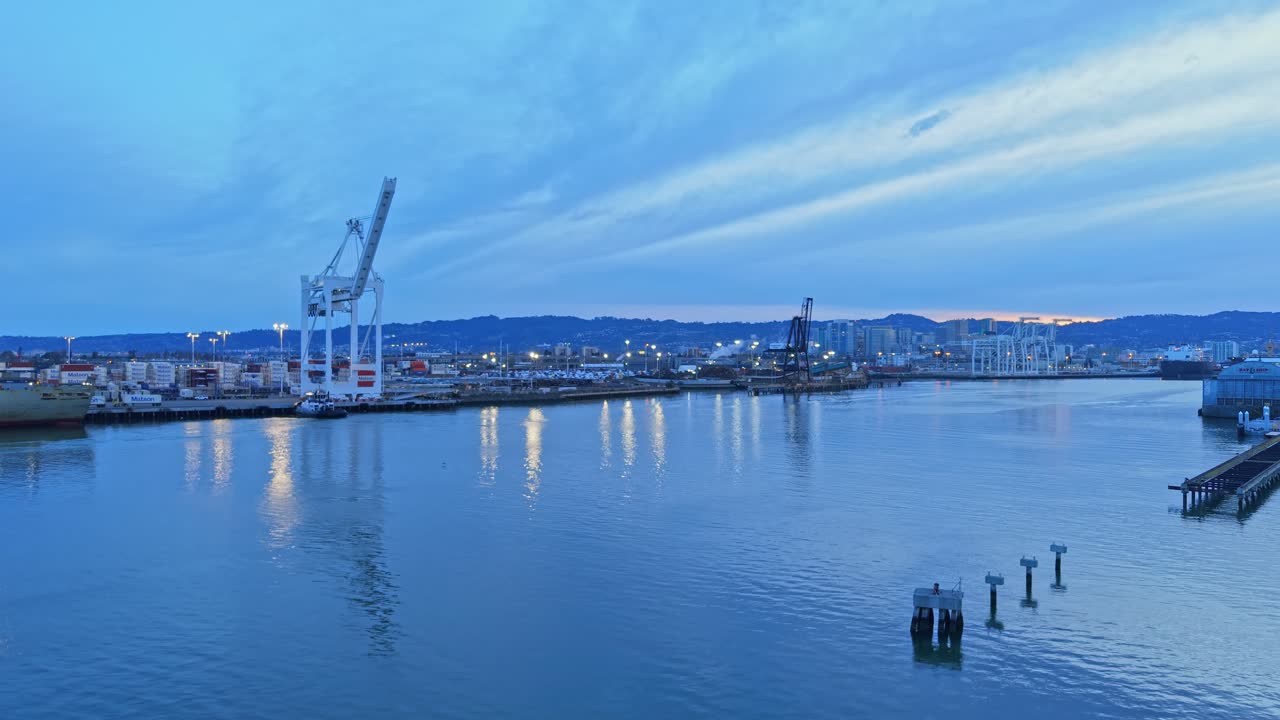An ascending aerial shot of the cranes along Oakland's Inner Harbor.