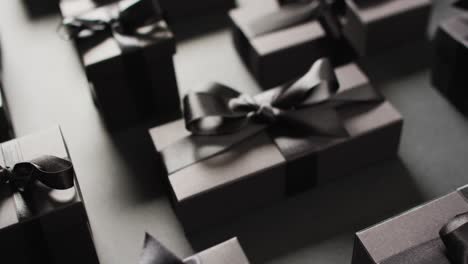 black gift boxes tied with black ribbons on black background