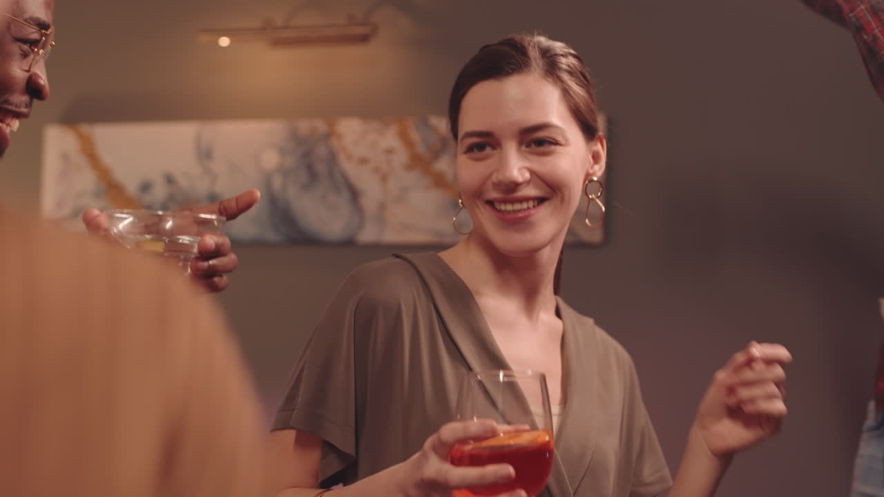 Young Brunette Female Dancing in Company of Friends at House Party