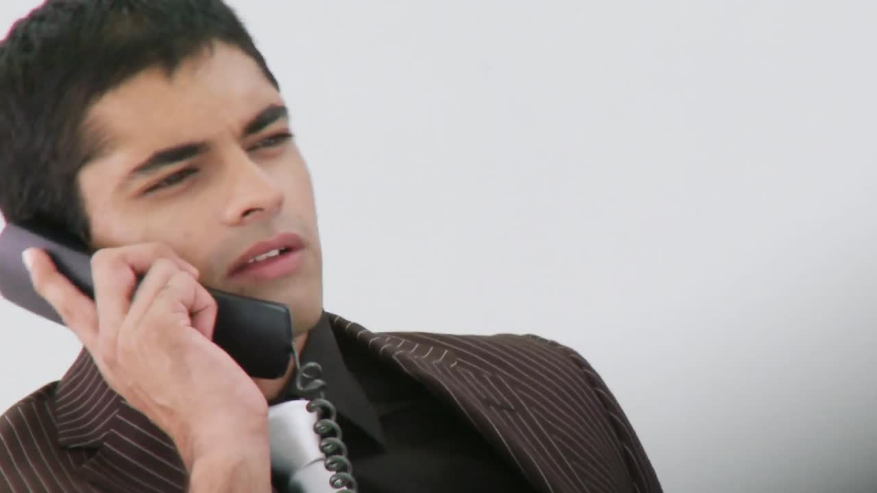 라틴 아메리카의 비즈니스맨이  ⁇ 드폰으로 일하고 있습니다.