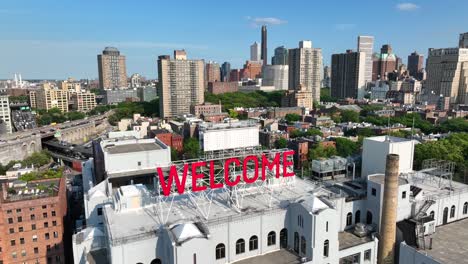 welcome sign in front of brooklyn, new york skyline