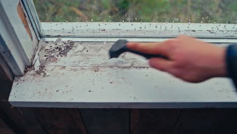 man repairing old window sill - close up