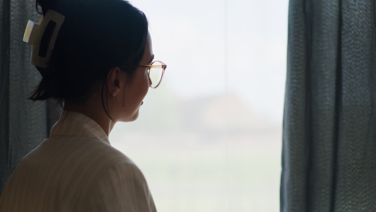 창문  에 있는 노트북 에 글 을 쓰고 있는 사려 깊은 여자