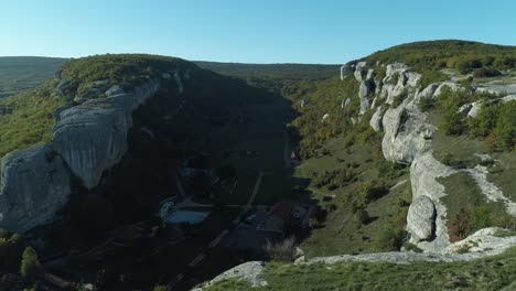 aerial view of a valley with cliffs and forests