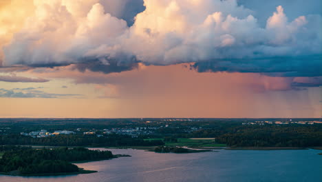 time lapse of a rain shower moving over a cityscape and forest, vibrant sunset