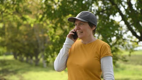 female farmer talking on mobile phone in organic walnut fruit orchard