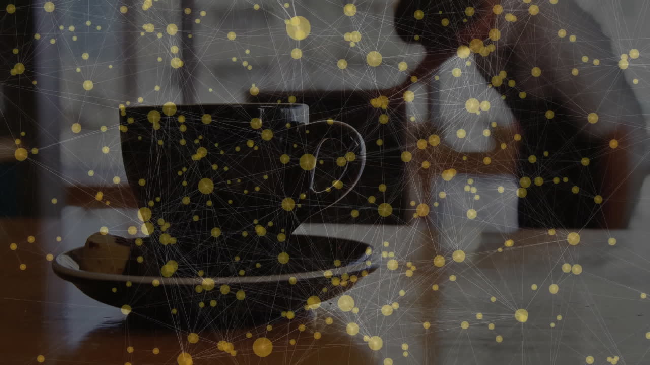 Black ceramic coffee cup being placed on saucer, displaying glowing network overlay over table