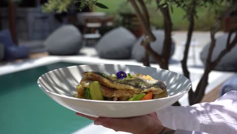 fresh fish is on the plate with carrot and zucchini