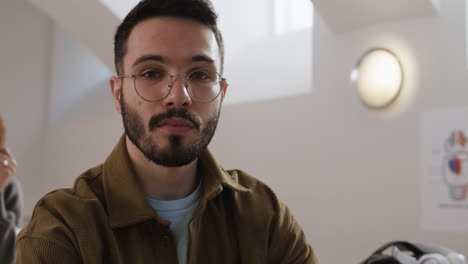a man with a beard and glasses studying
