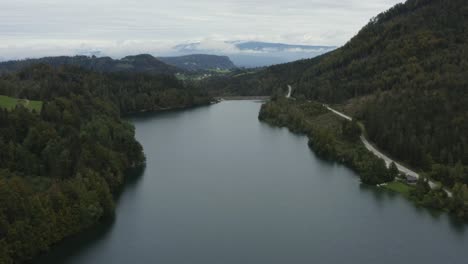 Embalse-De-Freibach-En-Los-Alpes-Del-Sur-De-Austria-En-Un-Día-Gris-Nublado,-Tiro-Ascendente-Aéreo