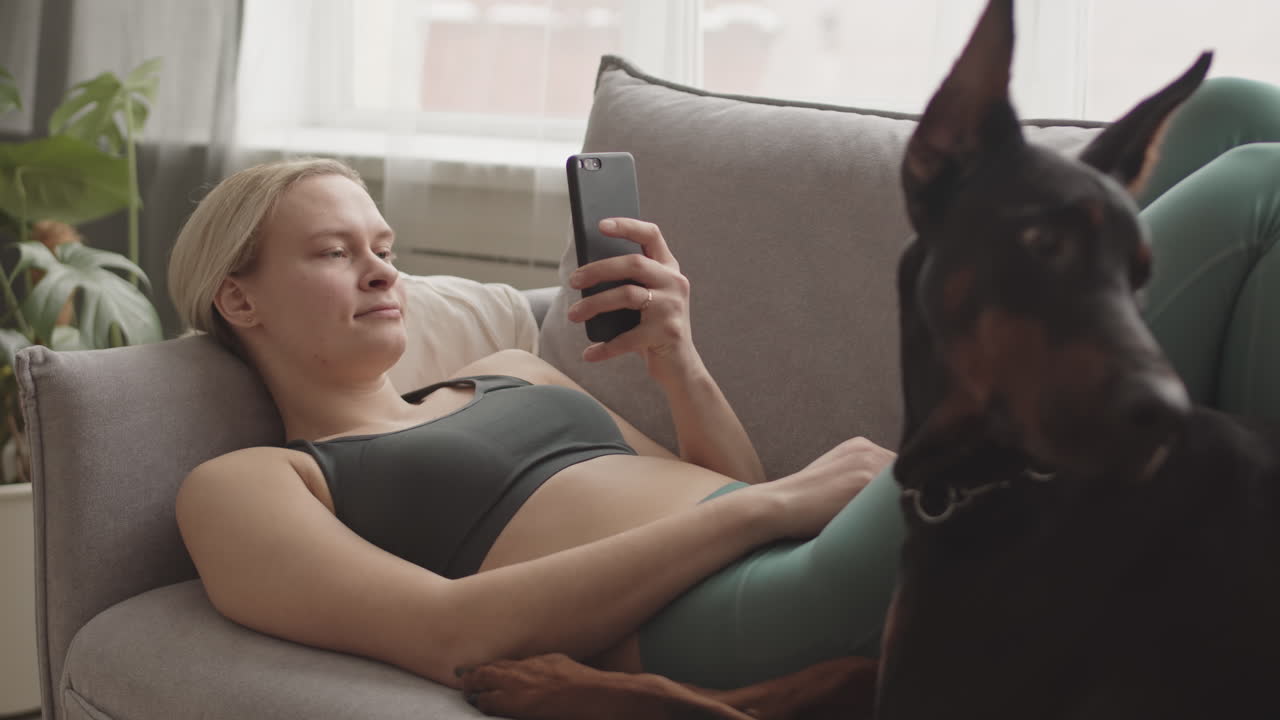 Sportswoman Resting with Dog and Smartphone