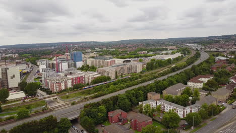 Die-Drohne-Schwenkt-Von-Links-Nach-Rechts-Und-Verfolgt-Den-Zug,-Der-Während-Des-Tages-Bewölkt-Durch-Hendon,-Die-Stadt-Im-Norden-Londons,-Fährt