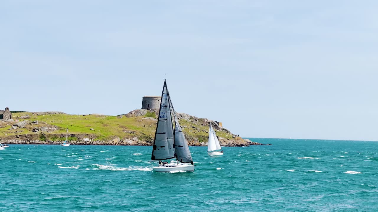 Dalkey Island is opposite Coliemore Harbour in Dalkey. On a sunny day, a sailboat attempting to push through the waves against a strong wind