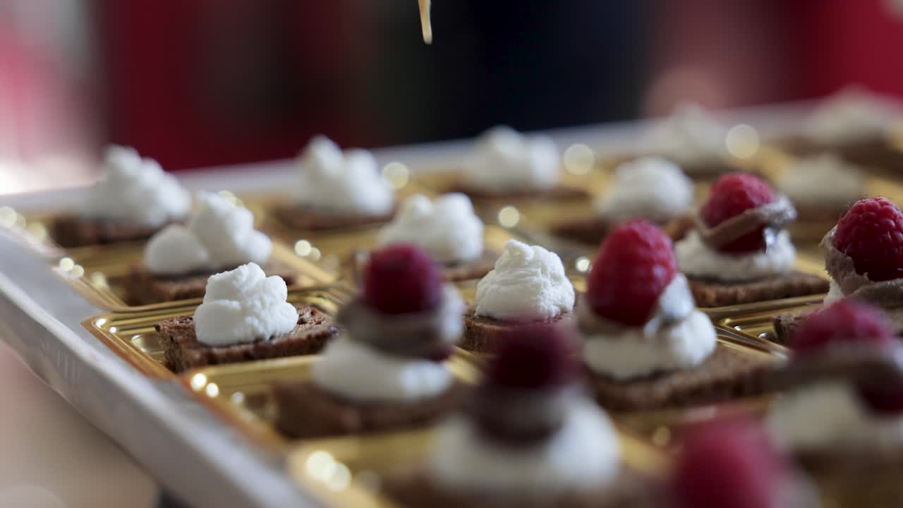 Chef placing berries on top of catering finger food ready to be served