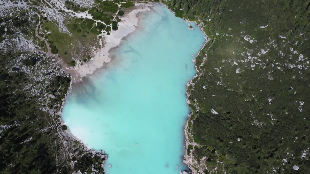 drone flies over the famous lake sorapis in the dolomites in italy, amazing deep blue water colour