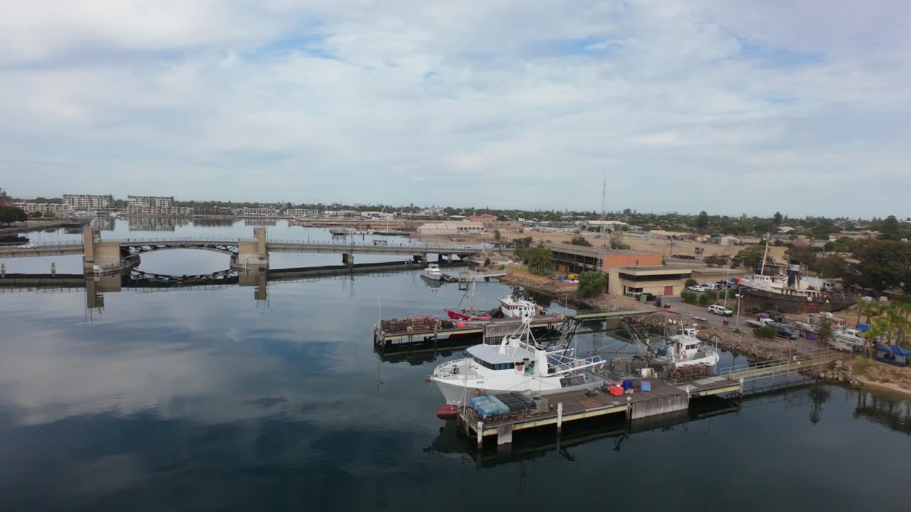 drone flight showing port Adelaide braw bridge and boats with a boat yard behind them