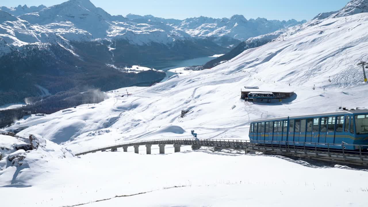 teleférico azul bajando rodeado de un paisaje invernal nevado y montañas en st.