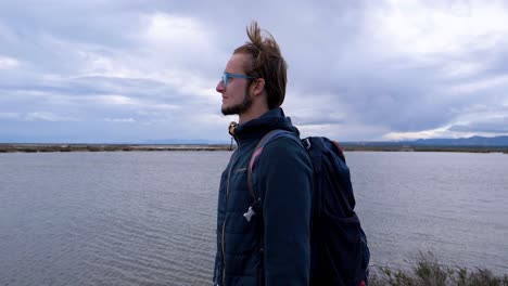 slow motion shot of a young man walking alongside the ocean neat the sete salt flats