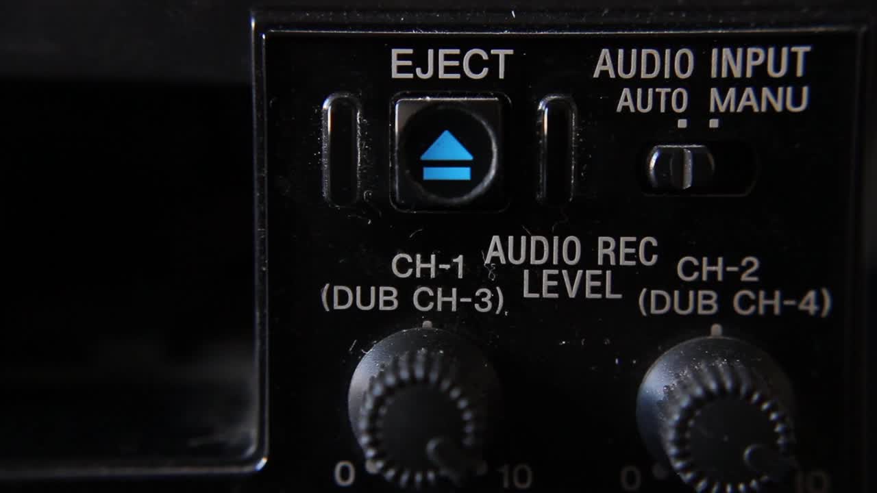 Finger trykker på udløserknappen på en vintage elektronisk enhed