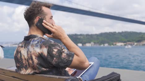 man working with tablet by the sea.