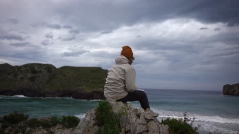 joven reflexionando hombre pensativo mirando en la distancia en el acantilado del océano