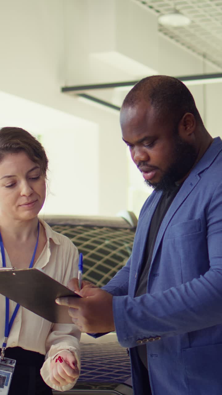 Car Saleswoman and Customer Signing Purchase Agreement and Shaking Hands