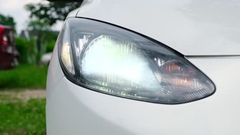 close up shot of blinking headlights in car