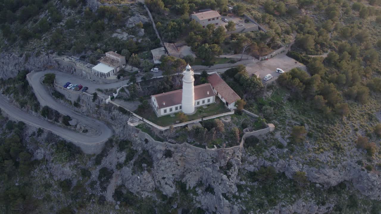 Pôr do sol dourado junto ao farol de Soller em falésias acidentadas