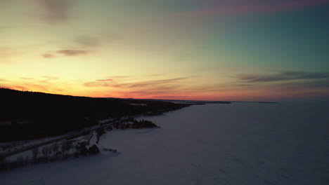 flying drone above a frozen lake in canada at golden hour