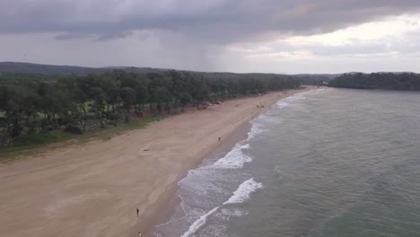 Scenic-View-Of-Rajbagh-Beach-In-Canacona,-South-Goa,-India-On-A-Cloudy-Day---aerial-pullback