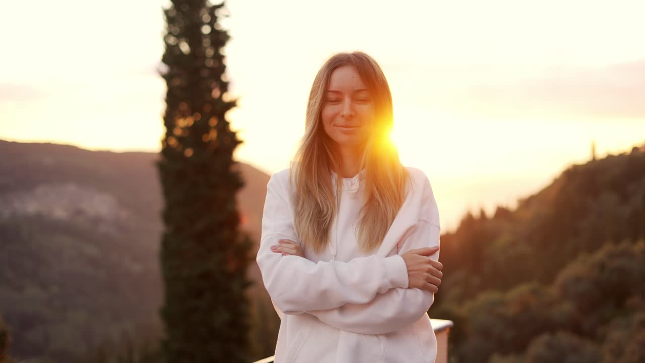 retrato de una mujer rubia disfrutando de las montañas en las bengalas de la lente