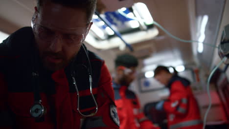 médico trabajando en el coche de emergencia. paramédicos del equipo moviéndose para una llamada de emergencia