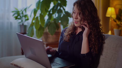 Portrait-Of-Businesswoman-Working-On-Laptop-While-Talking-On-Mobile-Phone