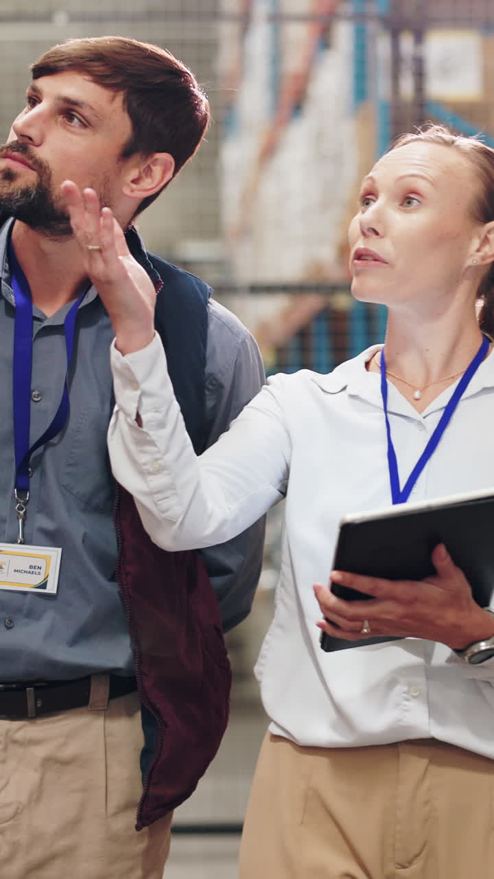 Dipendenti di magazzino che parlano di lavoro con un tablet