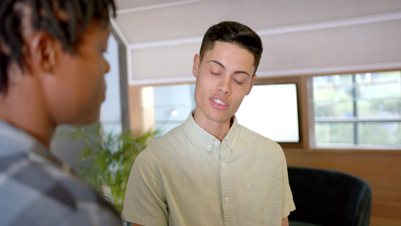 Discussing work, two colleagues having conversation in modern office setting