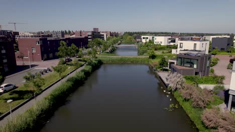 Antena-De-Viviendas-Contemporáneas-En-El-Barrio-Residencial-Leidsche-Rijn-Vista-Desde-Arriba-Del-Canal-Que-Rodea-La-Isla-Urbana.