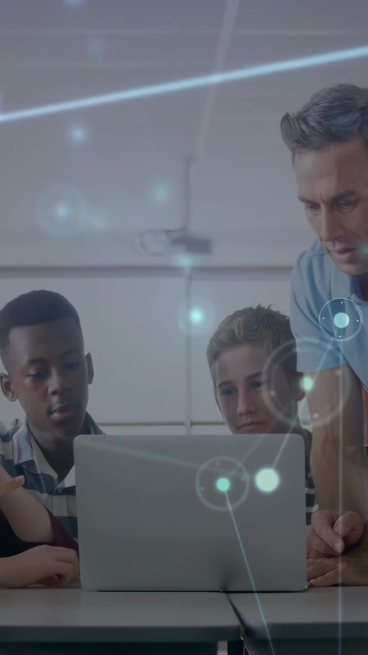 Vertical video: Teacher placing hand on laptop teaching class, network overlay moving around laptop