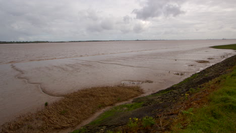 wide shot of the humber estuary showing low tide mudflats and flood wall