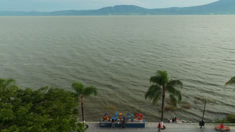 aerial top down shot of lake chapala and auditorium in ajijic city. rising view. housing area and homes in mexico.