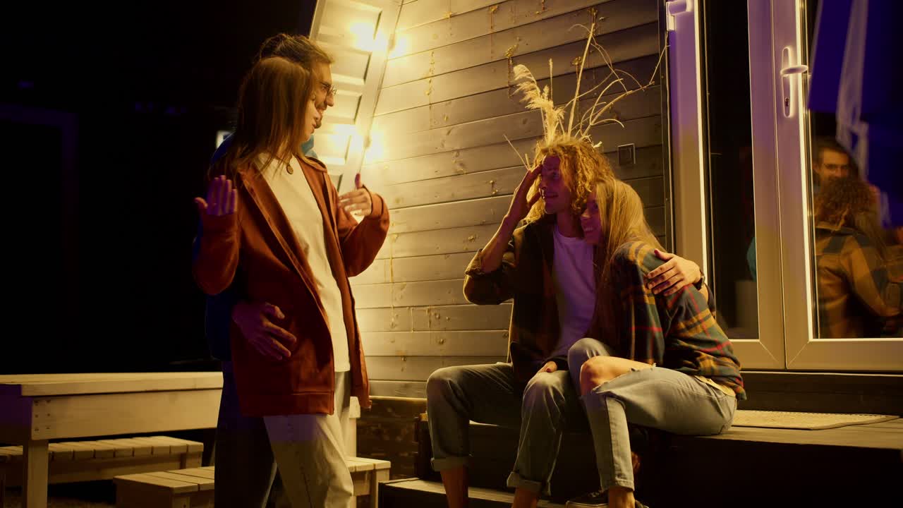 две пары общаются друг с другом за пределами дома. вечеринка за пределами города. отдых в загородном доме в выходные